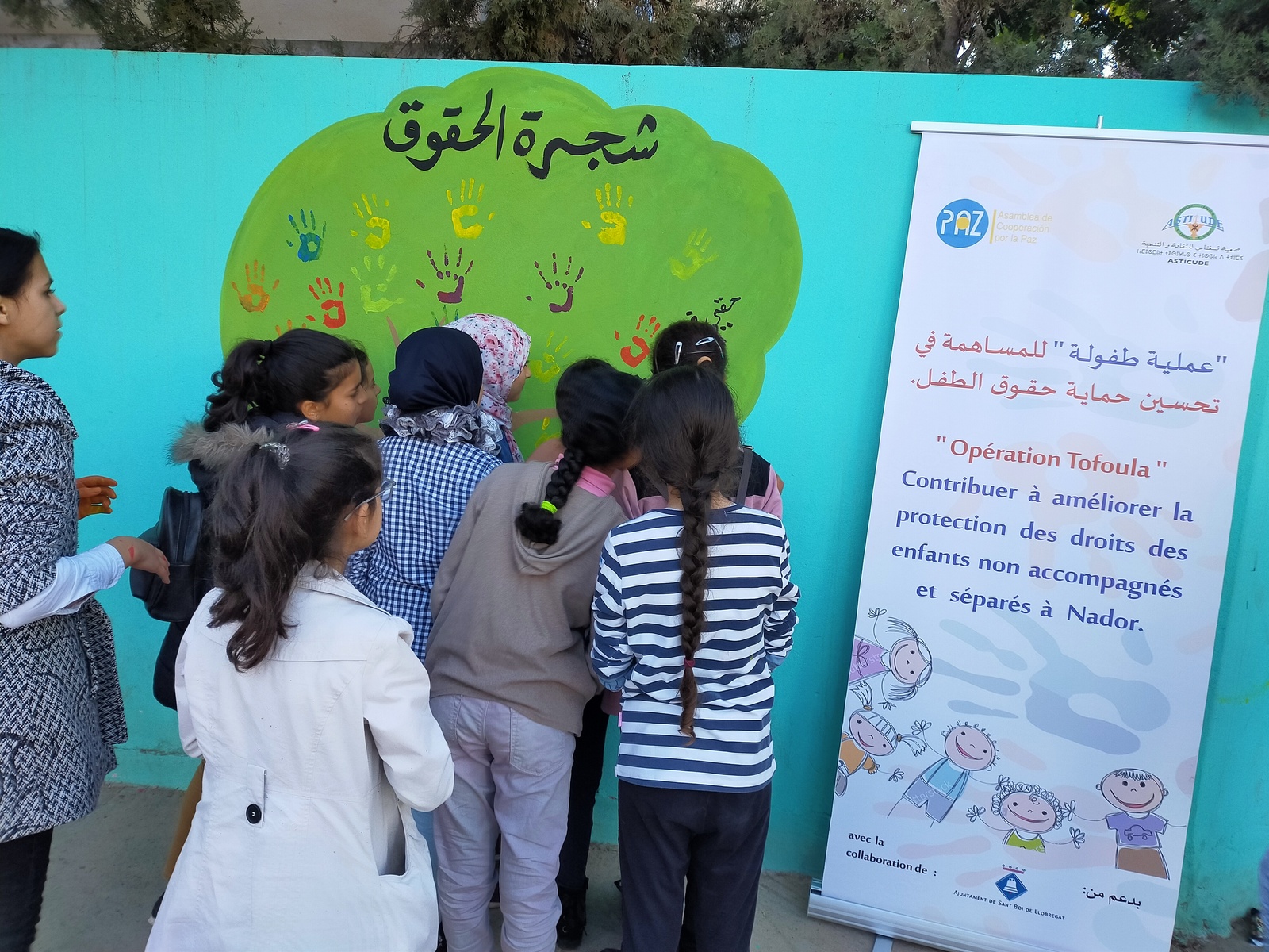 Nenes mirant un cartell en àrab